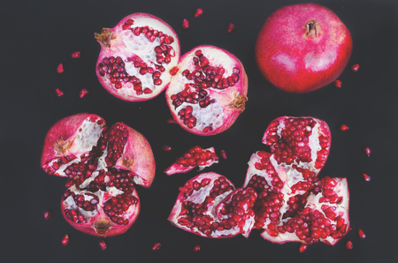Broken pomegranate and grains on black background. Copy space.の写真素材