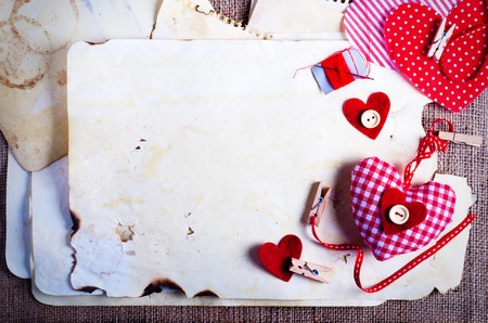 Red polka dot textile hearts on burlap. Free space for your textの写真素材