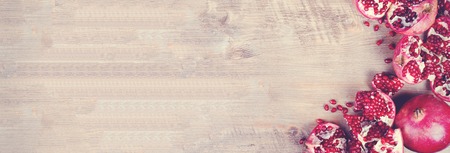 Ripe juice pomegranate fruit on black background - whole and cut, top view. Banner.の写真素材