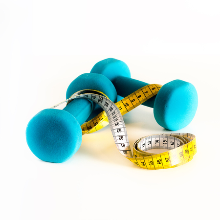 Fitness concept. Turquoise dumbbells and yellow measuring tape. Copyspaceの写真素材
