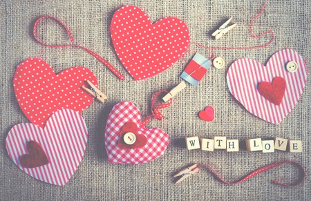 Sewing set: fabrics, threads, pins, buttons, tape and handmade hearts on burlap, sackcloth background. Tonedの写真素材