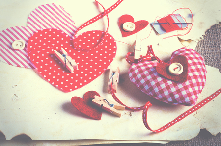 Sewing set: fabrics, threads, pins, buttons, tape and handmade hearts on burlap, sackcloth background. Tonedの写真素材