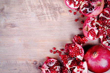 Ripe juice pomegranate fruit on black background - whole and cut, top viewの写真素材