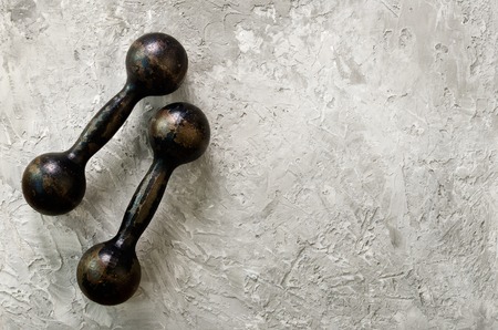 Old dumbbells on concrete background. Sport concept. Free space for your textの写真素材