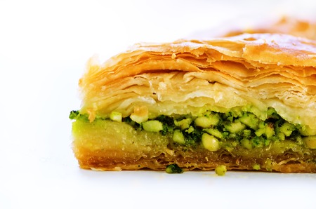 Baklava with pistachios, walnuts and honey on white background. Jewish, turkish, arabic traditional national dessert. Macro. Selective focus. Copy space.の写真素材