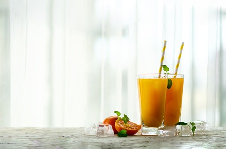 Fresh orange juice, mint and ice on white background, top view, copy space. Summer cocktail, drinkの写真素材
