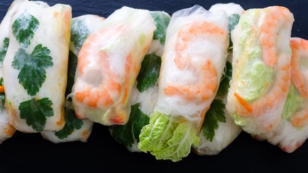 Vietnamese spring rolls - rice paper, lettuce, salad, vermicelli, noodles, shrimps, fish sauce, sweet chili, soy, lemon, veletables. Copy space. Asian and thai food. Traditional national cuisineの写真素材