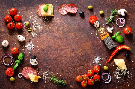 Food ingredients and spices for cooking pizza. Mushrooms, tomatoes, cheese, onion, oil, pepper, salt, basil, grater, olive on rustic background. Copyspace. Top viewの写真素材