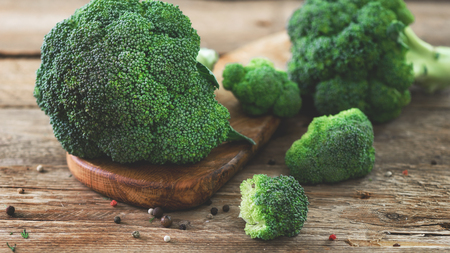 Fresh organic broccoli on wooden table close up