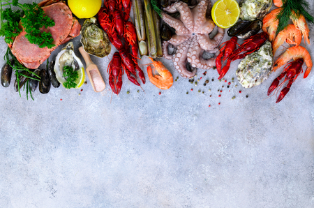 Seafood background - fresh mussels, molluscs, oysters, octopus, razor shells, shrimps, crab, crawfish, crayfish, seaweed, lemon, spices. Banner with copyspaceの写真素材