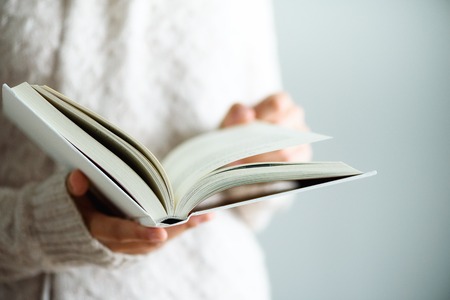 Young girl in white T-shirt reading opened book. Copy space. lifestyle and school conceptの写真素材