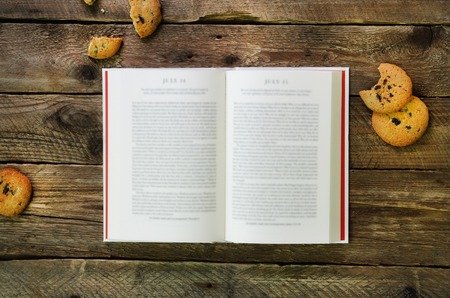 Ð¡offee cup, opened book, alarm clock, cookie on wooden rustic vintage background. Top view, copy space.の写真素材