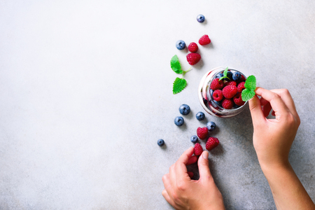 Woman hands decorating delicious dessert, chia pudding. Copy space, top viewの写真素材