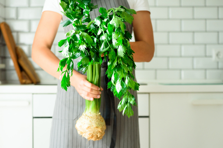 Woman hands holding fresh organic celery. vegetables, onion, tomatoes, corn, bell pepper, spinach, lettuce leaves. Clean eating, detox conceptの写真素材