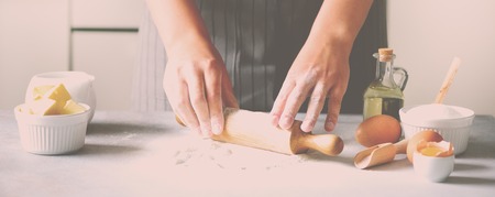 Female hands kneading dough, baking background. Cooking ingredients - eggs, flour, sugar, butter,...