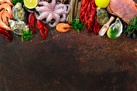 Seafood background - fresh mussels, molluscs, oysters, octopus, razor shells, shrimps, crab, crawfish, crayfish, seaweed, lemon, spices. Banner with copyspaceの写真素材