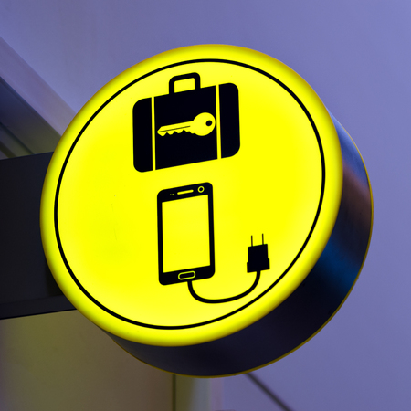 Charging mobile, cellphone battery icon in public area, airport. Locker luggage sign. Copy spaceの写真素材