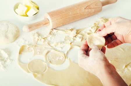 Traditional russian pelmeni, ravioli, dumplings with meat on black concrete background. Parsley,...