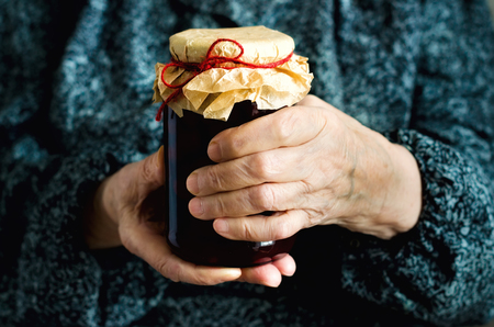Senior woman holding jar of homemade cherry jam. Banner. Copy spaceの写真素材