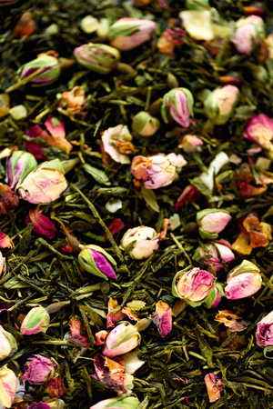 Texture of green tea with rose petals. Dried rosebuds background texture closeup.