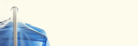 Blue color clothes. Male clothes, jackets and shirts hanging on clothes rail. Copy space. Banner.の写真素材