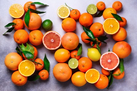 Citrus fruits background. Assorted fresh citrus fruits with leaves. Orange, grapefruit, lemon, lime, tangerine. Top viewの写真素材