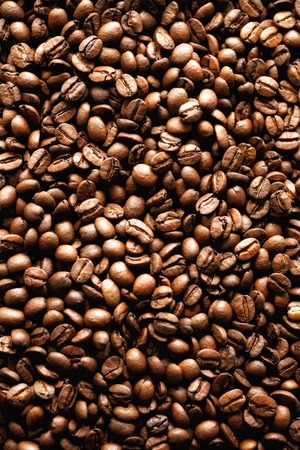 Roasted coffee beans backgound, copy space, top view. Cappuccino, dark espresso, aroma black...