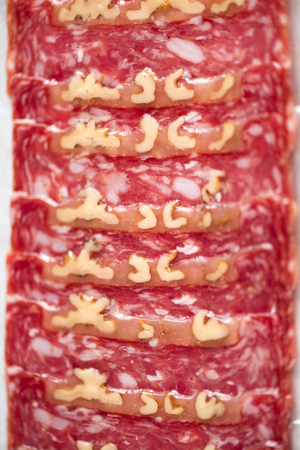 Prosciutto with nuts texture close up. Top view, copy space. Sliced italian prosciutto background.の写真素材