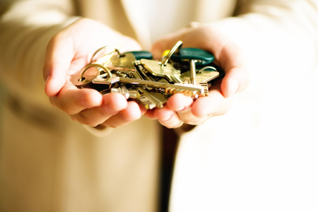 Many keys in hands on light background. Sunny morning light. Copy spaceの写真素材