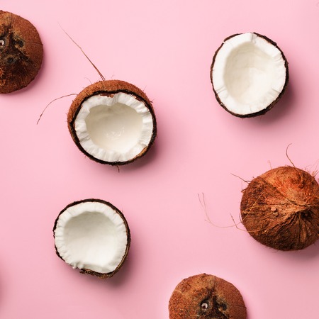 Pattern with ripe coconuts on pink background. Top View. Copy Space. Square crop. Pop art design, creative summer concept. Banner. Half of coconut in minimal flat lay styleの写真素材