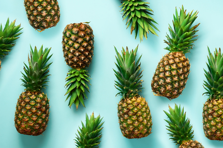 Fresh pineapples on blue background. Top View. Pop art design, creative concept. Copy Space. Bright pineapple pattern for minimal styleの写真素材