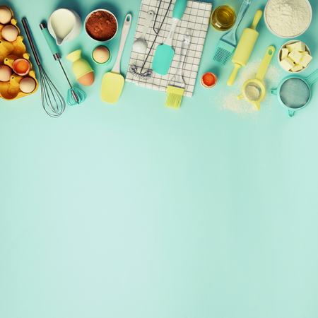 Square crop. Baking ingredients - butter, sugar, flour, eggs, oil, spoon, rolling pin, brush, whisk, towel over blue background. Bakery food frame, cooking concept. Top view, copy space. Flat lay.の写真素材
