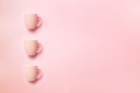 Row with pink cups over punchy background. Birthday party celebration, baby shower concept. Pastel...