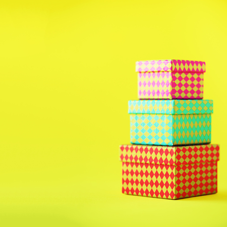 Collection of colorful gift boxes on yellow background. Square crop. Presents for birthday party....