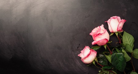 Pink roses on black chalkboard. Happy Women's Day. Valentine's Day concept. Present for her.の写真素材