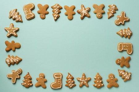 Frame of Christmas gingerbread cookies on blue background