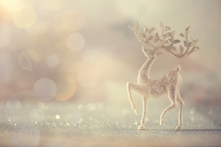 Silver glitter Christmas deer on grey background with lights bokeh, copy space. Greeting card for new year party. Festive holiday concept. Banner.の写真素材