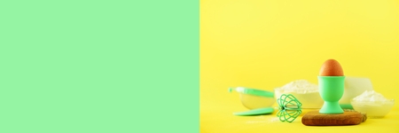 Turquoise and yellow cooking utensils on bright background. Food ingredients. Macro of eggs. Cooking cakes and baking bread concept. Copy space. Banner.の写真素材
