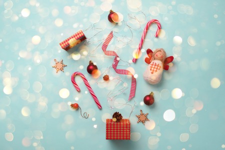 Greeting card with snow, lights bokeh for New year party. Christmas gifts, decorative elements and ornaments on blue background. Top view. Winter holiday concept.の写真素材