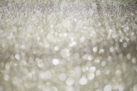 Silver glitter background with abstract bokeh lights. New year and Christmas concept. Sparkling greeting card.の写真素材