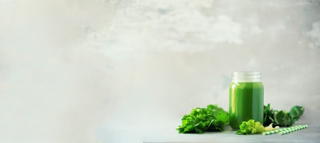 Bottle of green celery smoothie on grey concreteの写真素材