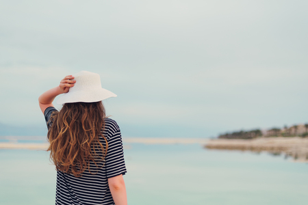 Young girl with shining blonde hair goes to seaside, Dead Sea beach.の写真素材
