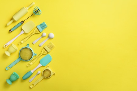 Turquoise cooking utensils on yellow background. Food ingredients. Cooking cakes and baking bread...