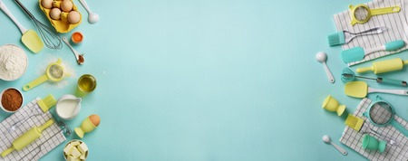 Time to bake. Banner of healthy food ingredients - butter, sugar, flour, eggs, oil, spoon, rolling pin, brush, whisk over blue background. Baking frame, cooking concept. Top view, copy space. Flat layの写真素材