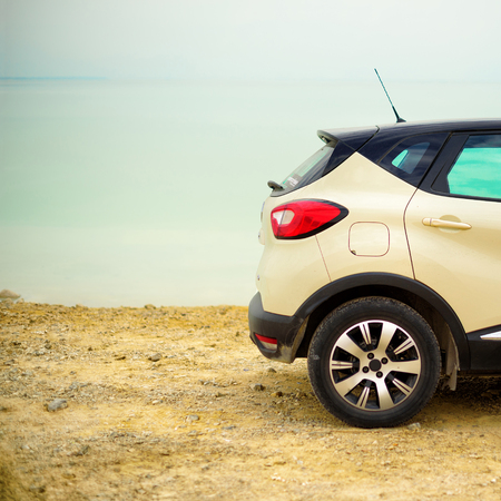 White crossover car on beach road. Banner. Travel, summer vacation, holiday, freedom concept. Digital detox.の写真素材