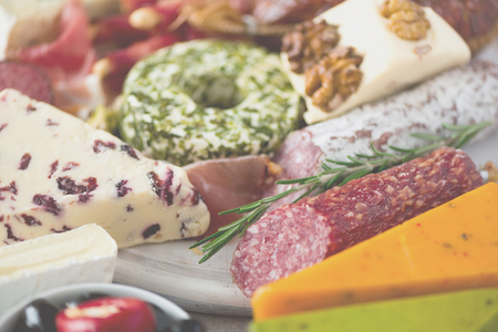 Cold smoked meat plate. Traditional italian antipasto, cutting board with salami, prosciutto, ham, pork chops, olives on greyの写真素材