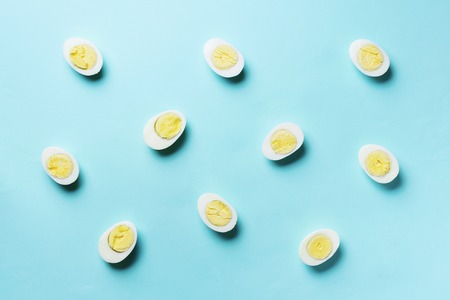 Boiled eggs pattern on blue background. Top view. Creative pattern. Minimal style. Flat lay. Food concept.の写真素材