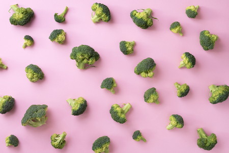 Creative layout of fresh broccoli on pink paper background. Top view. Food pattern in minimal style. Flat layの写真素材