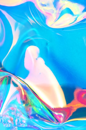 Holographic iridescent surface. Copy space. Bright colorful hologram background. Wrinkled abstract...