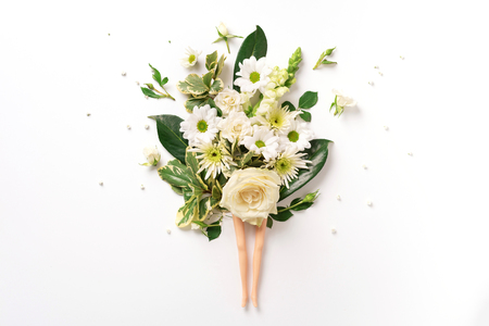 Doll legs and white rose, flowers, leaves on light background. Contemporary art collage. Spa, body treatment and skin care concept. Top view. Creative layout.の写真素材